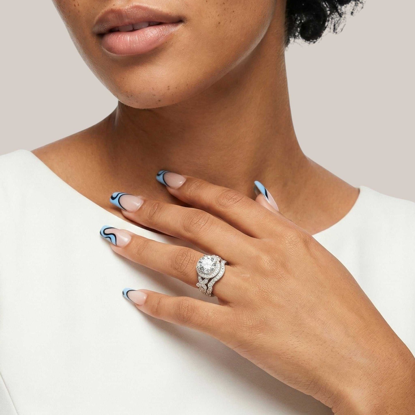 Close-up of a hand wearing a diamond ring with a neutral background