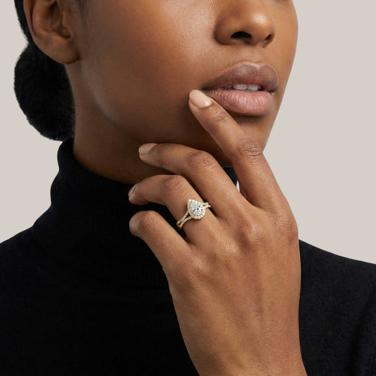 Woman wearing a diamond ring on her finger against a neutral background