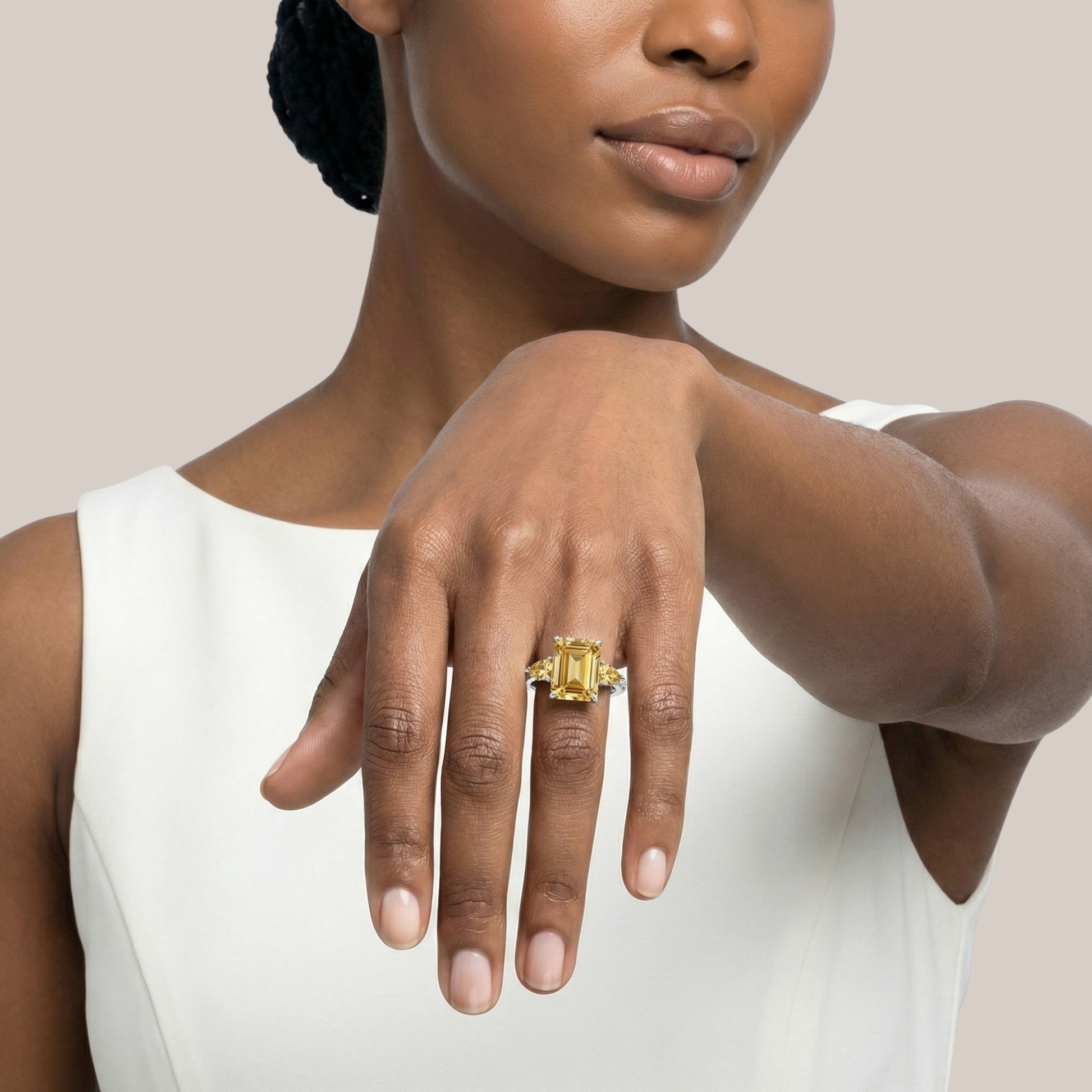 Woman wearing a gold ring on her hand against a neutral background