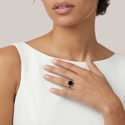 Woman wearing a black ring on her hand with a white background