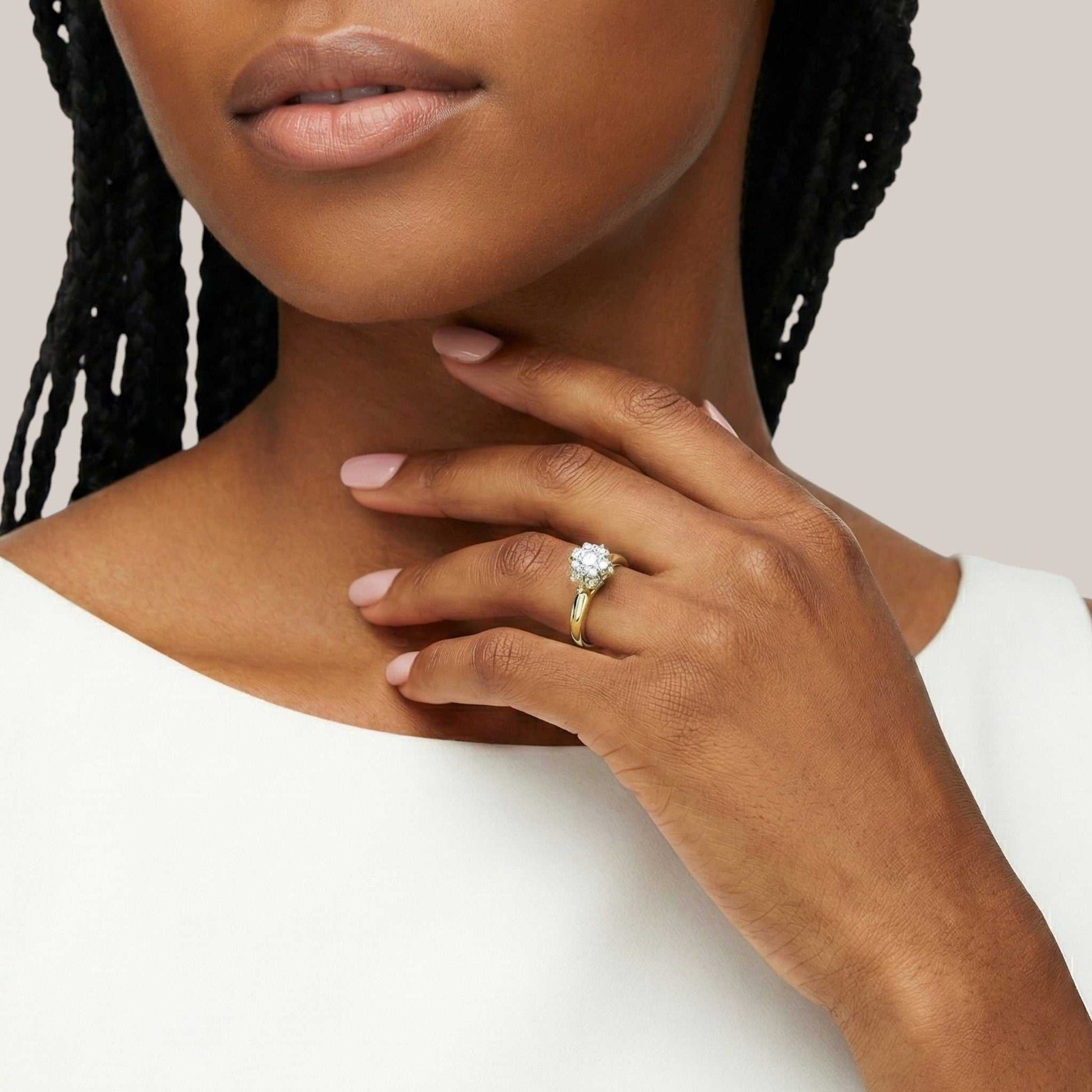 Woman wearing a gold ring with a diamond on a neutral background