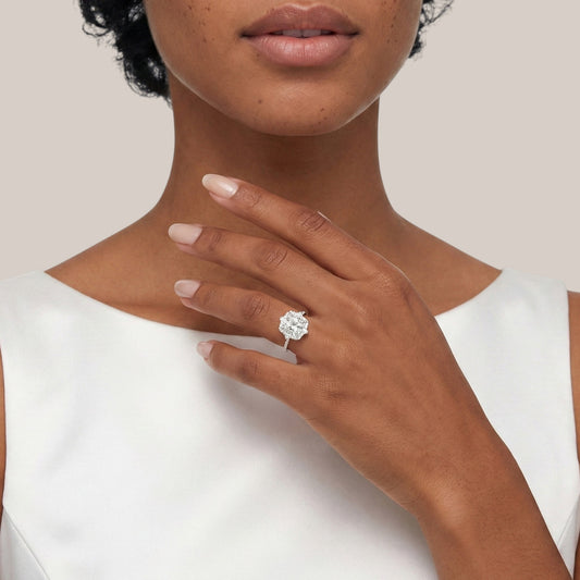 Woman wearing a diamond ring on a plain background