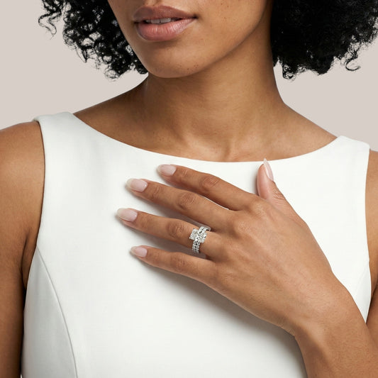 Woman wearing a diamond ring on a plain background