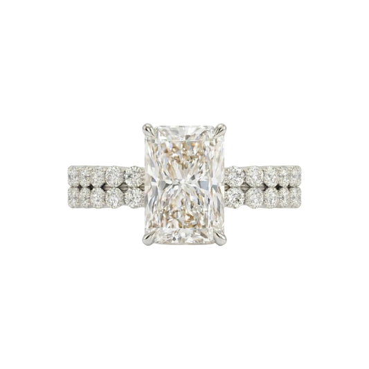 Diamond ring with a rectangular center stone on a white background