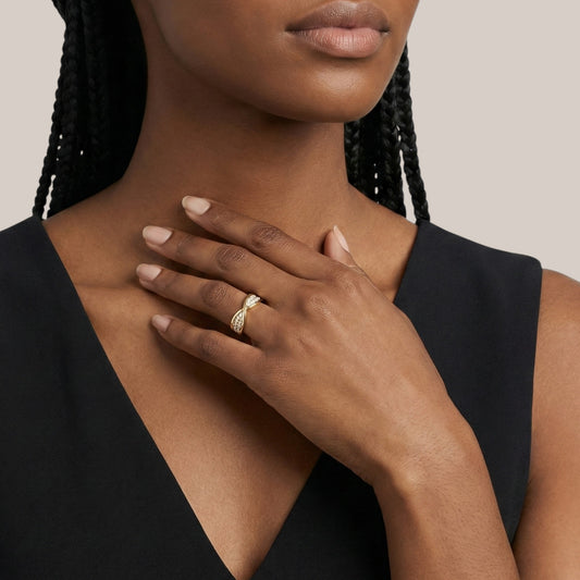 Woman wearing a gold ring on her hand with a neutral background
