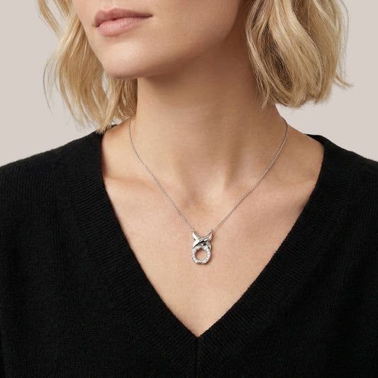 Necklace with a pendant worn by a person against a neutral background