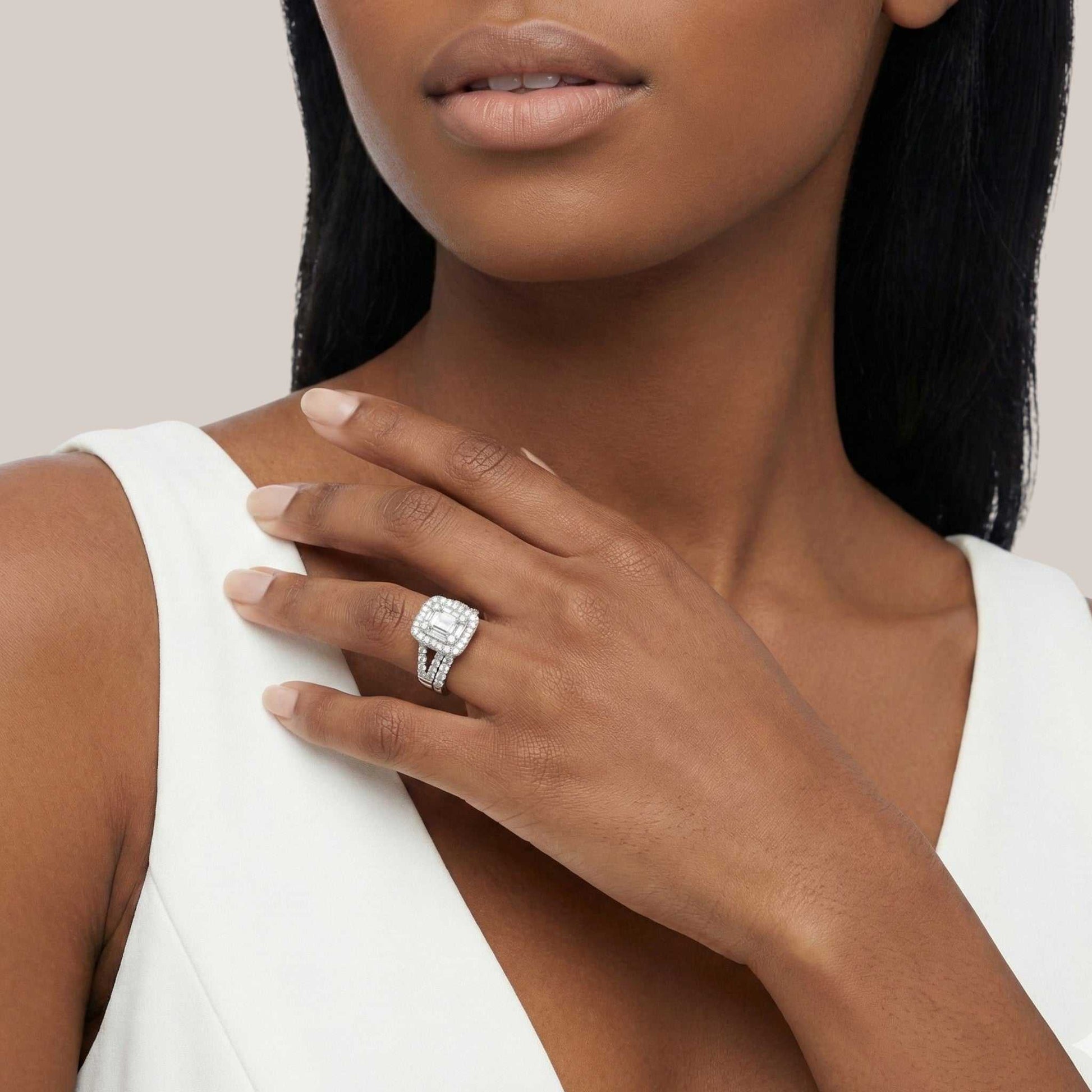 Woman wearing a diamond ring on her hand against a neutral background