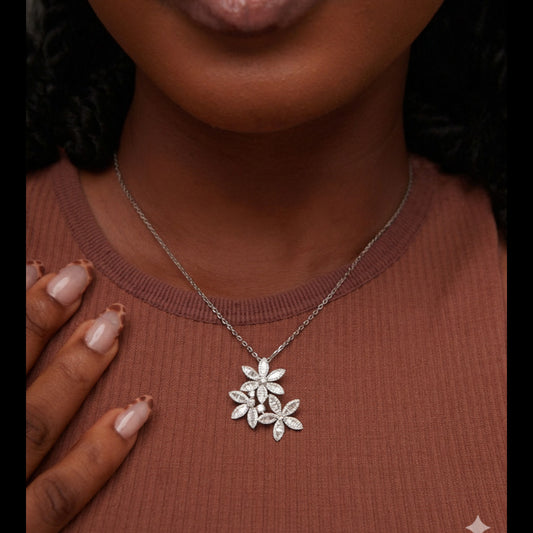 Silver necklace with a floral pendant worn by a person
