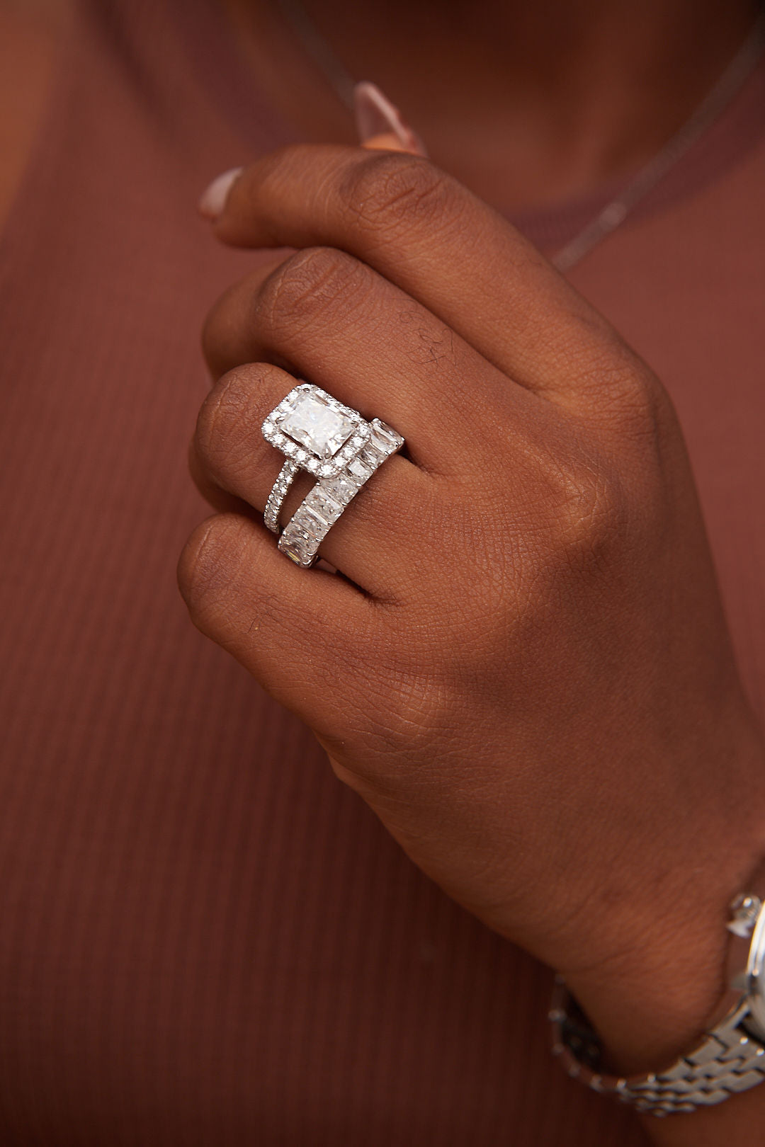 Close-up of a hand wearing a diamond ring with a blurred background