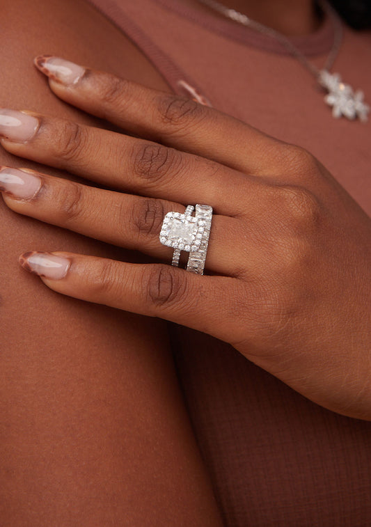 Close-up of a hand wearing a diamond ring on a brown background