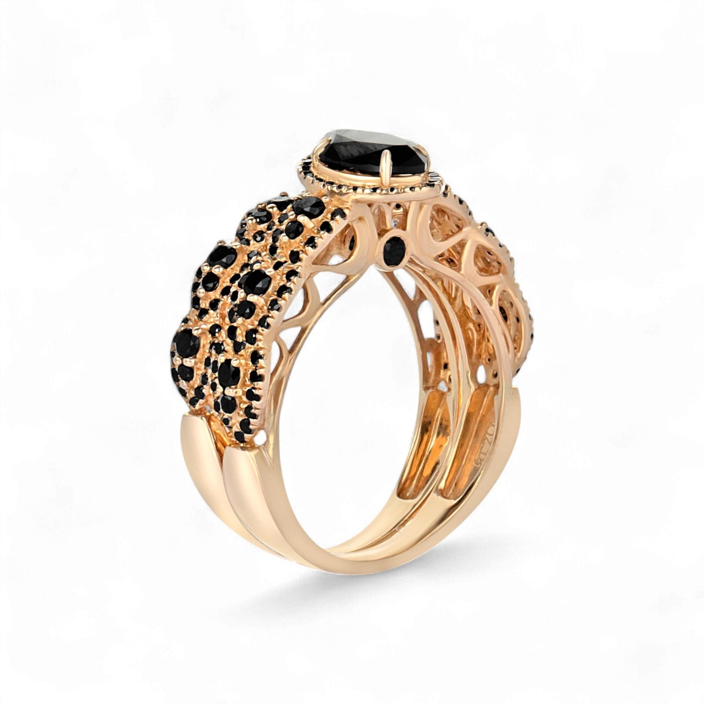 Rose gold ring with black gemstones on a white background