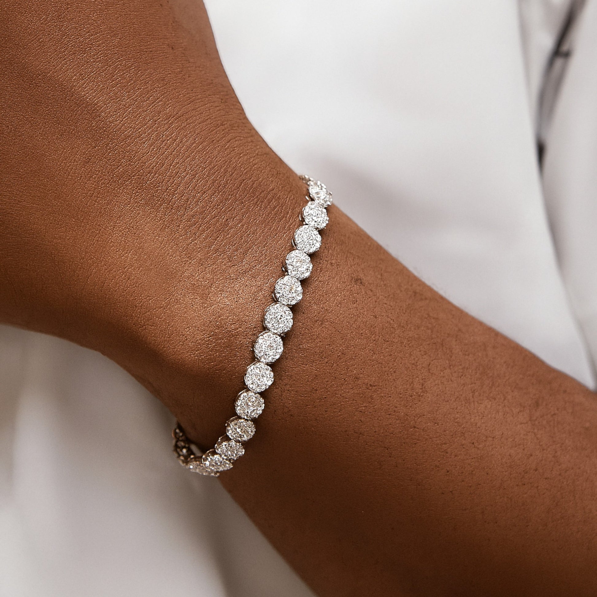 Silver bracelet on a wrist with a plain background