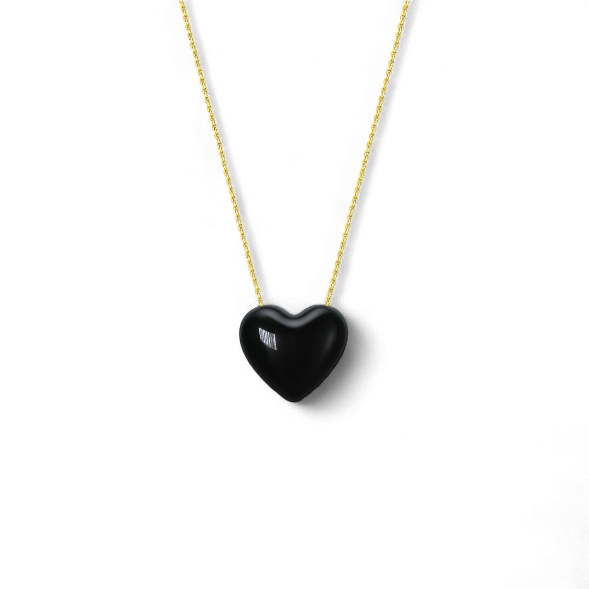 Black heart-shaped pendant on a gold chain against a white background