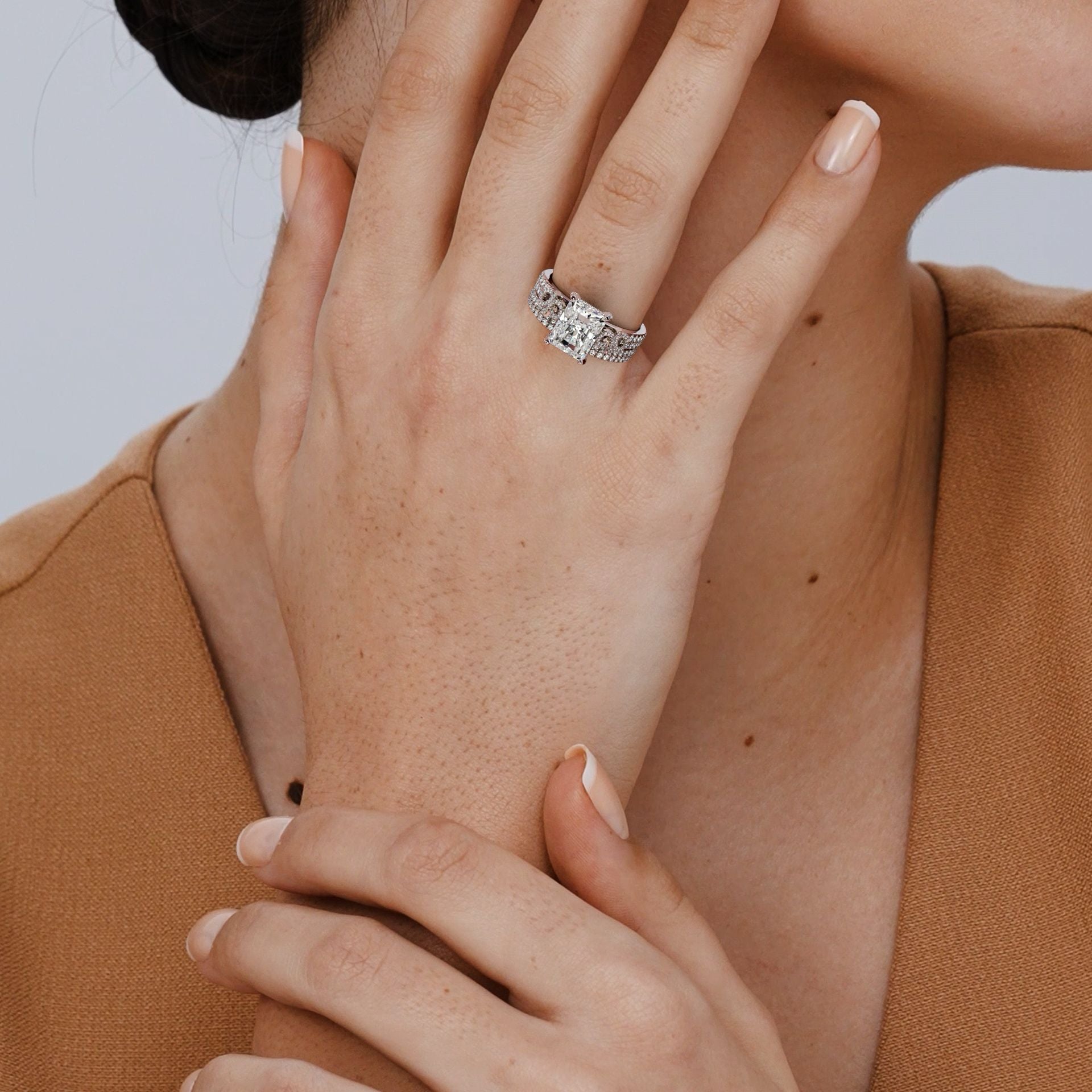 Close-up of a hand wearing a diamond ring with a blurred background