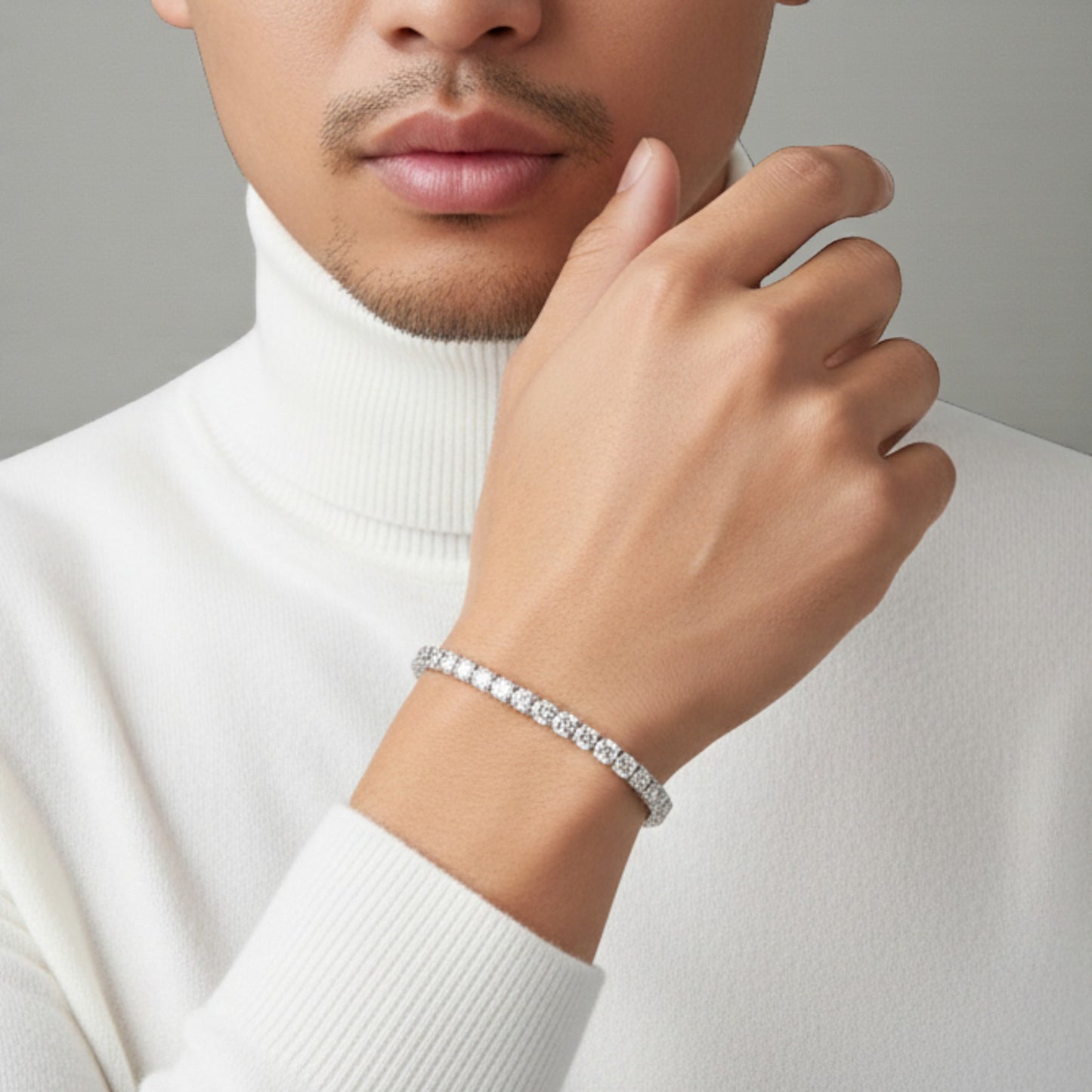 Person wearing a silver bracelet on a neutral background