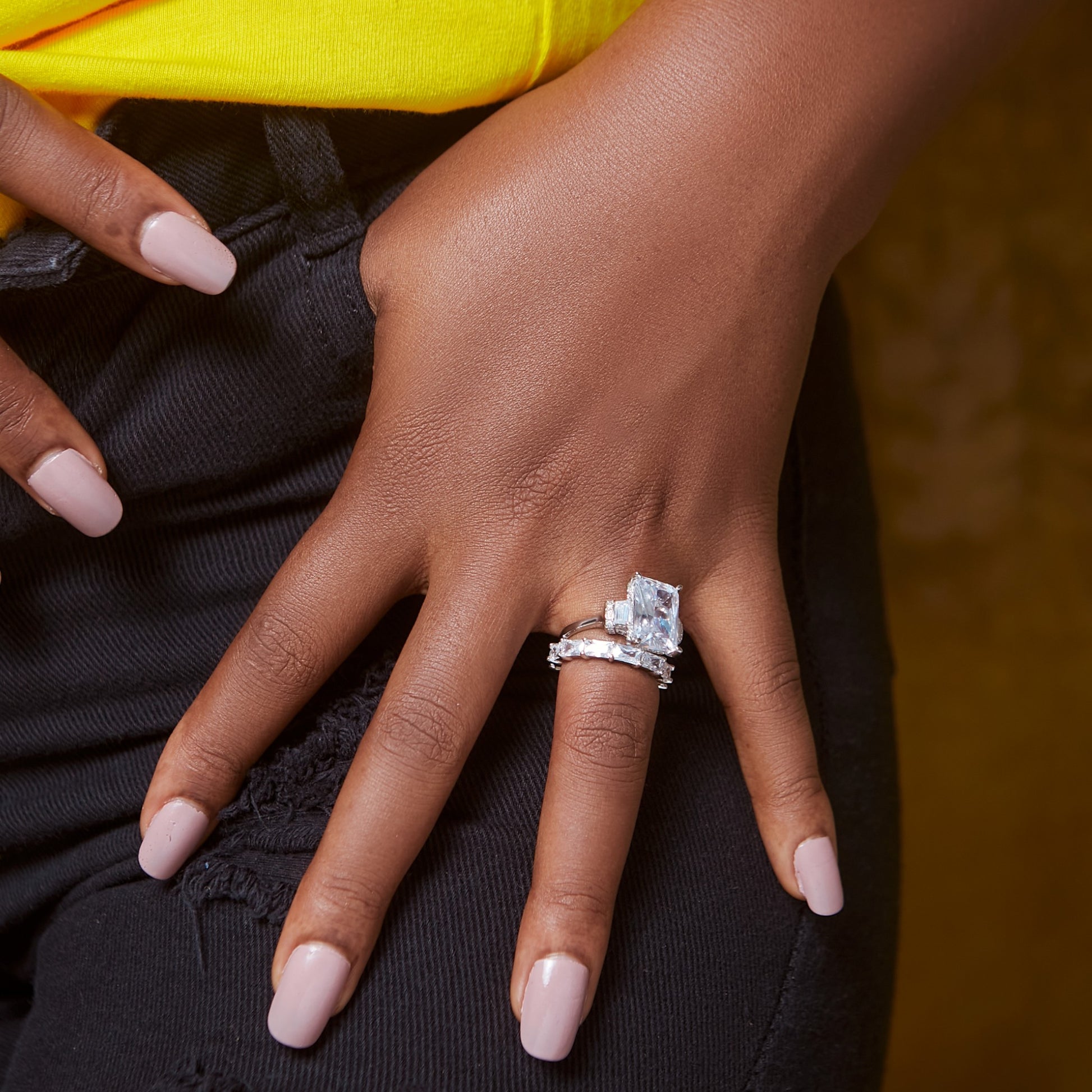 Hand wearing a diamond ring with a blurred background