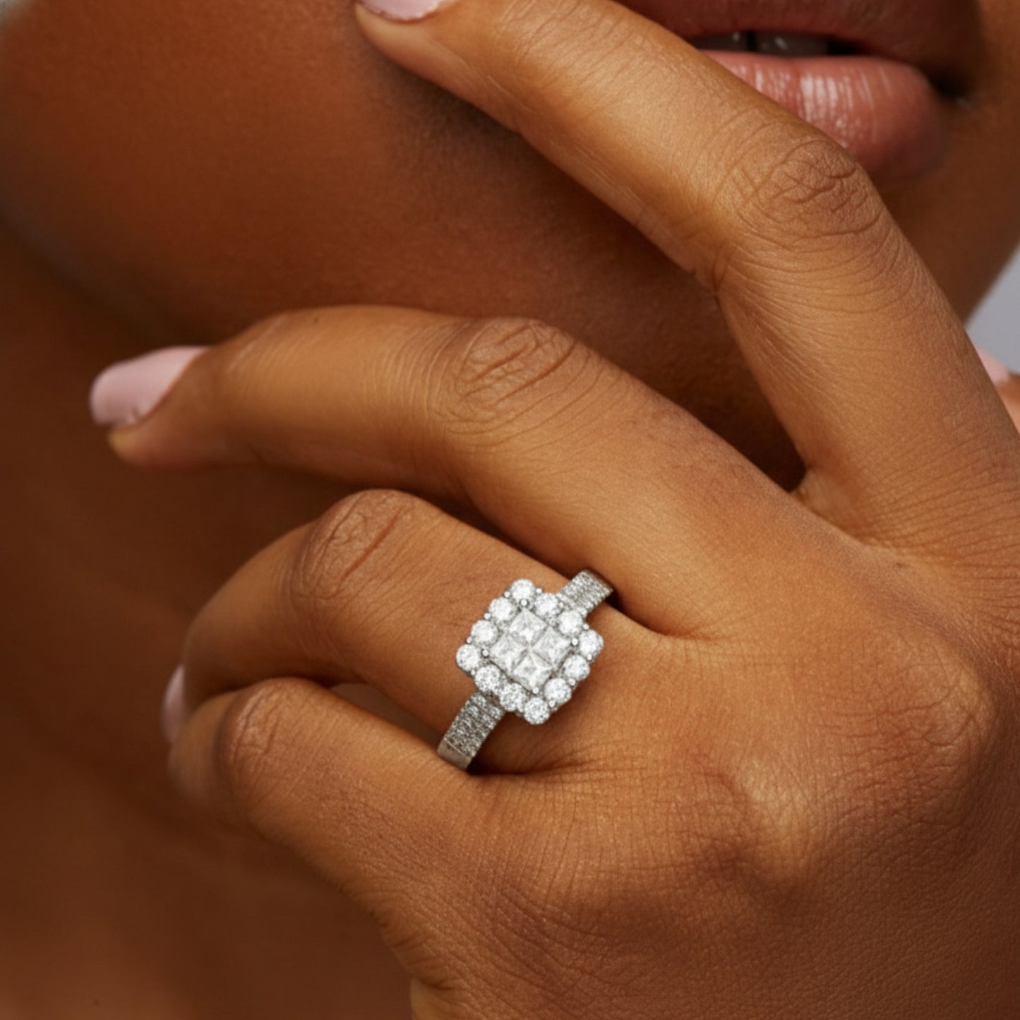Close-up of a hand wearing a diamond ring with a blurred background