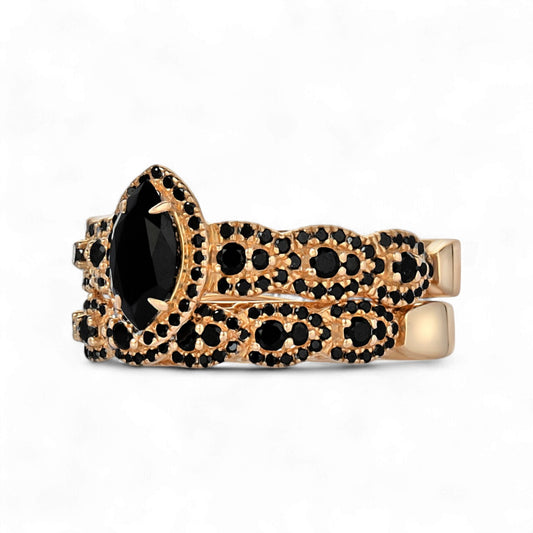 Gold ring with black gemstones on a white background