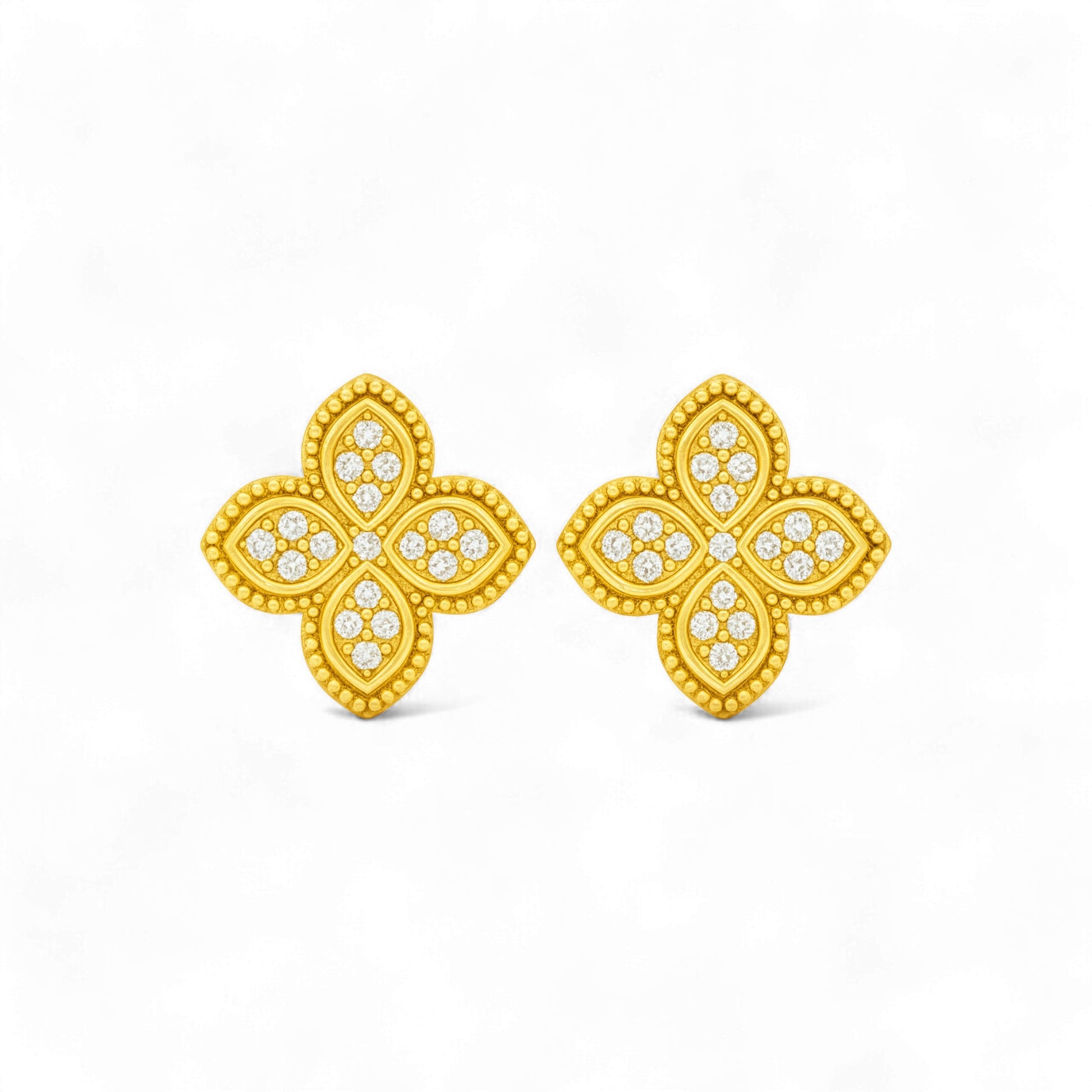 Gold butterfly earrings with diamond-like stones on a white background