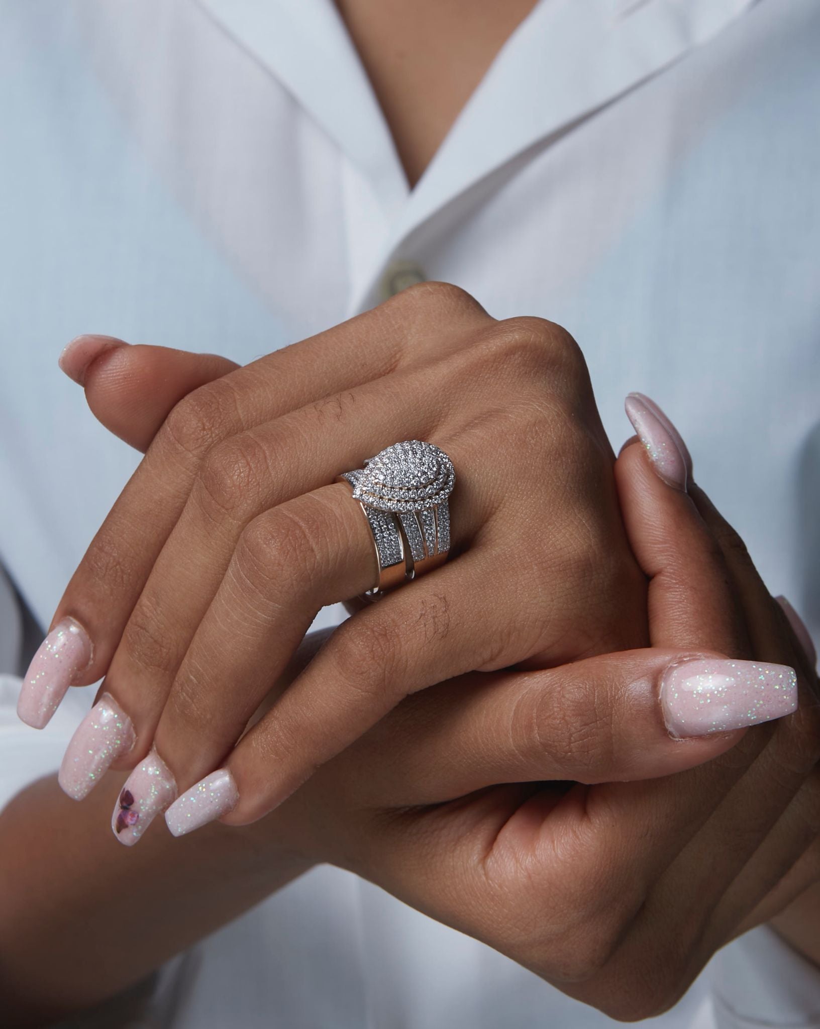 A woman's hand displaying a diamond ring on her finger.