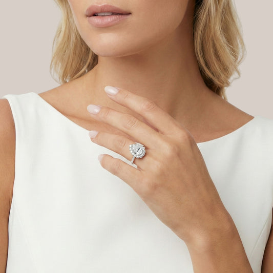 Close-up of a woman's hand wearing a diamond ring on a plain background
