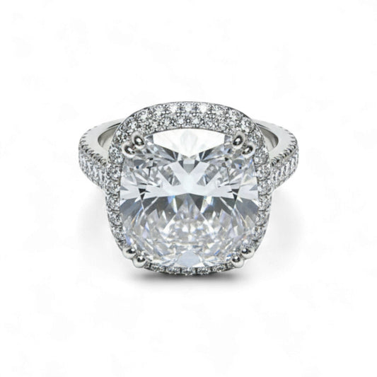 Diamond ring with a large central gemstone and smaller stones around on a white background