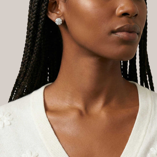 Close-up of a woman wearing a white sweater with a neutral background