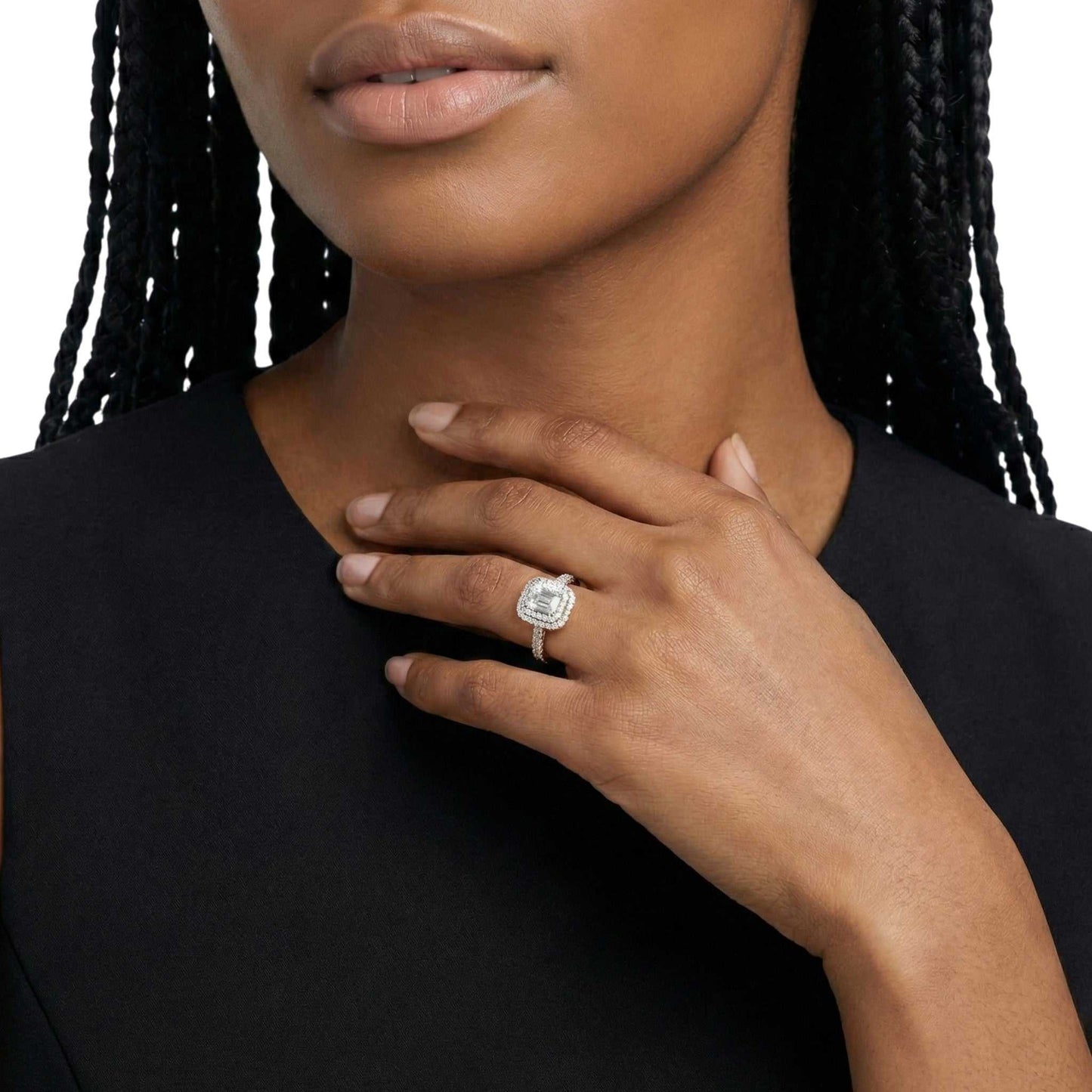 Close-up of a woman wearing a diamond ring on her hand against a neutral background