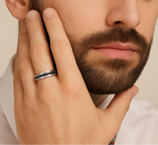 Close-up of a man's hand with a silver ring on his finger, touching his beard.