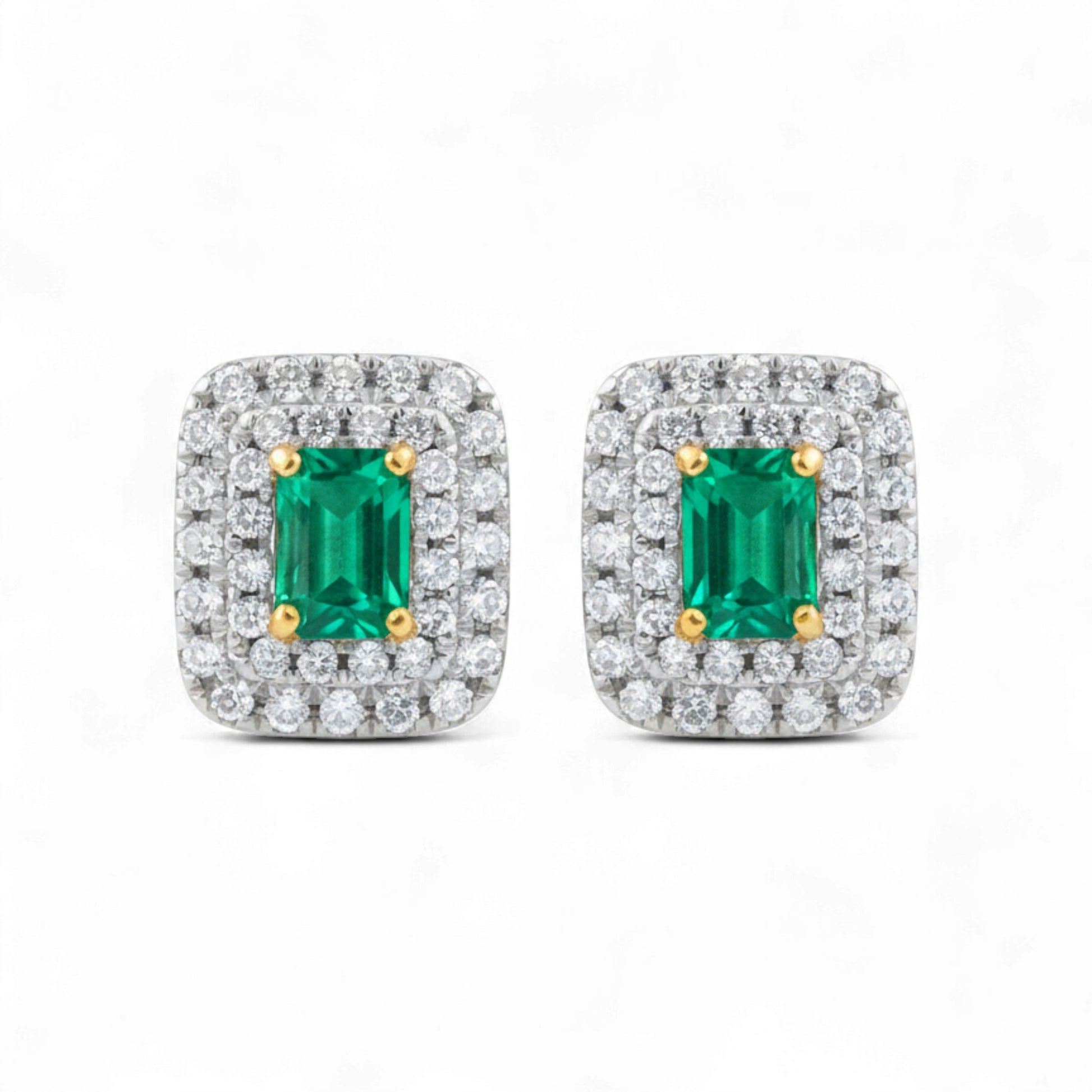 Pair of emerald cut gemstone earrings with diamond accents on a white background