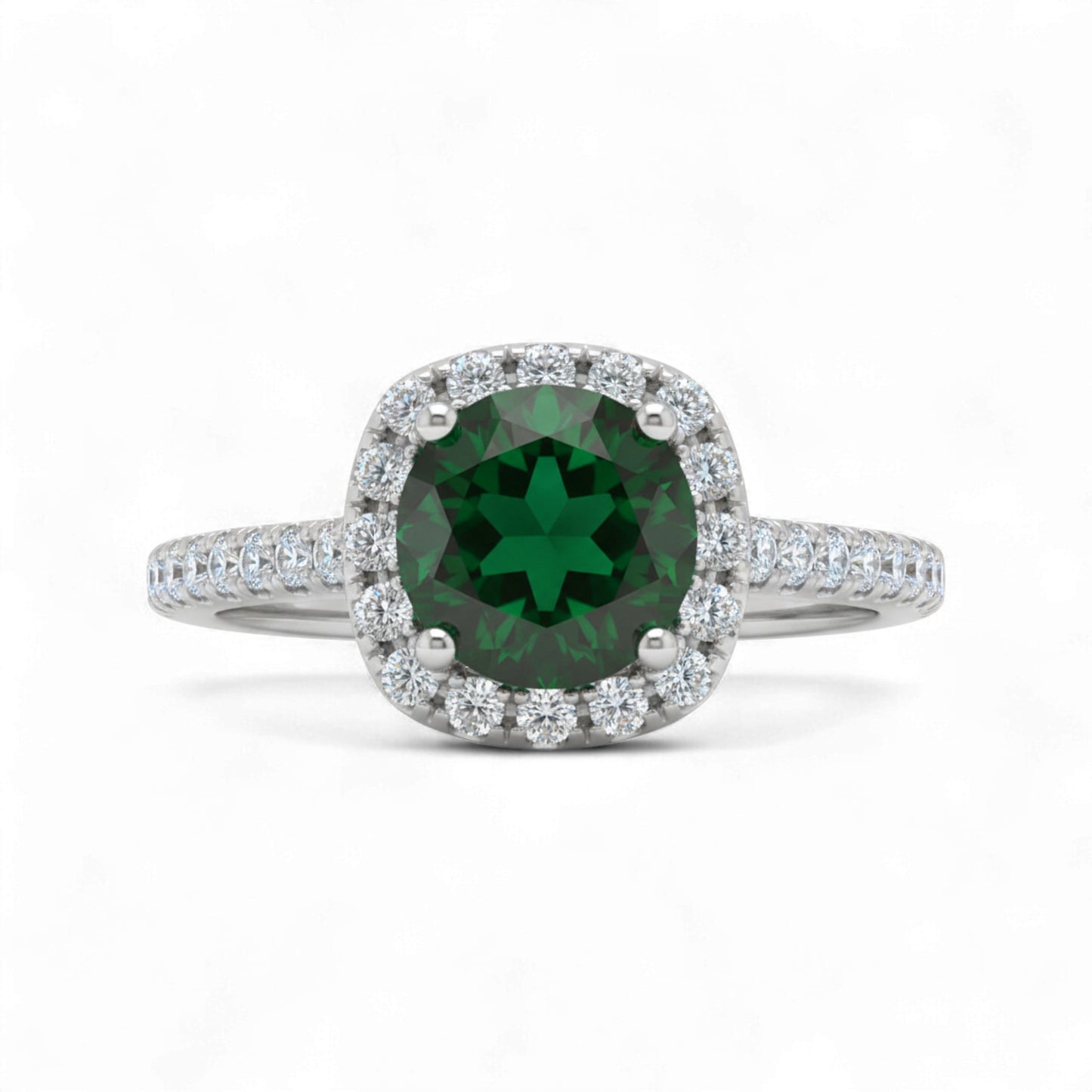 Ring with a green gemstone and diamond halo on a white background