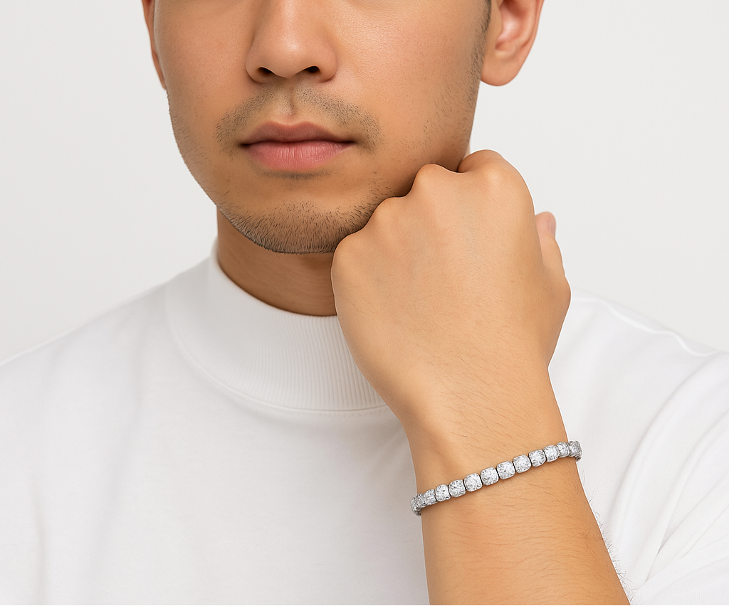 Man wearing a diamond bracelet on a plain background