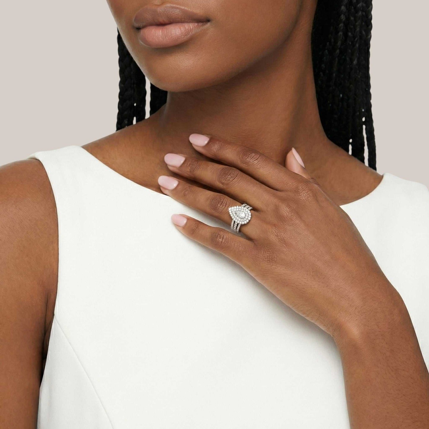 Woman wearing a diamond ring on her hand with a neutral background