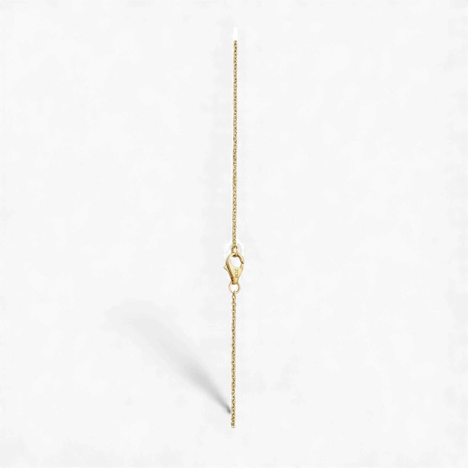 Gold chain necklace on a light gray background