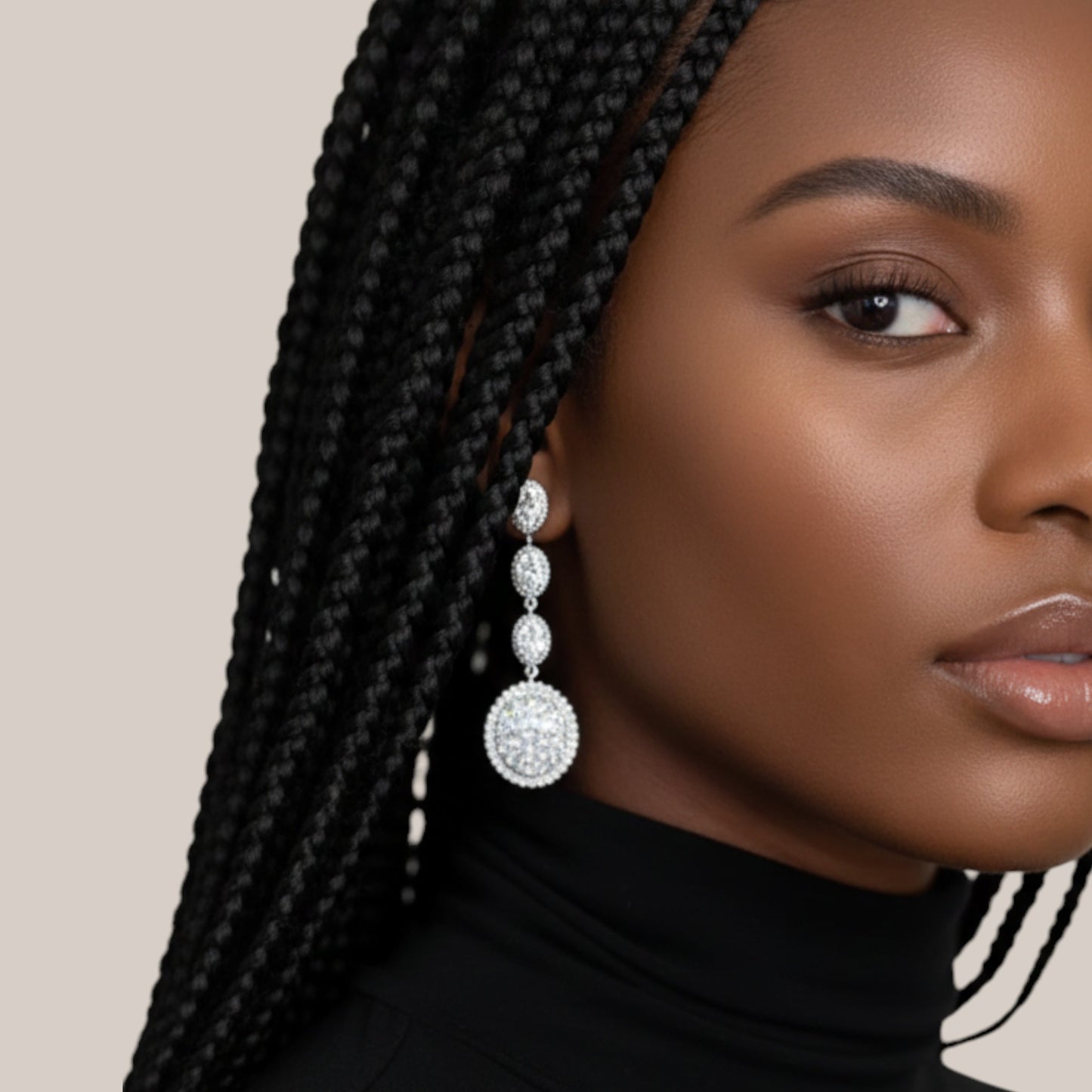 Close-up of a woman wearing a black turtleneck and large, sparkling earrings with a neutral background
