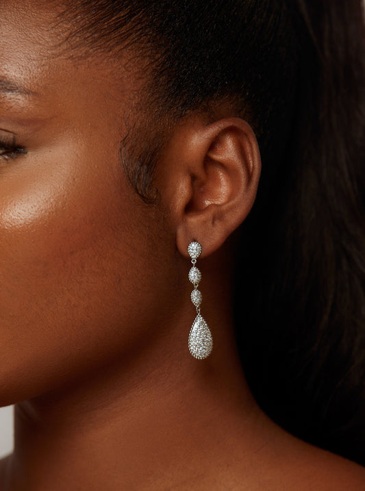 Close-up of a woman wearing a diamond earring.