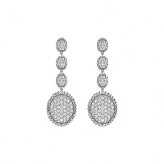 Pair of silver earrings with clear stones on a white background
