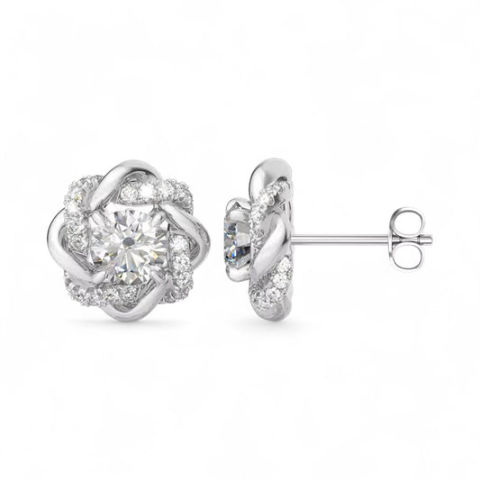 Silver earrings with a floral design and clear gemstones on a white background