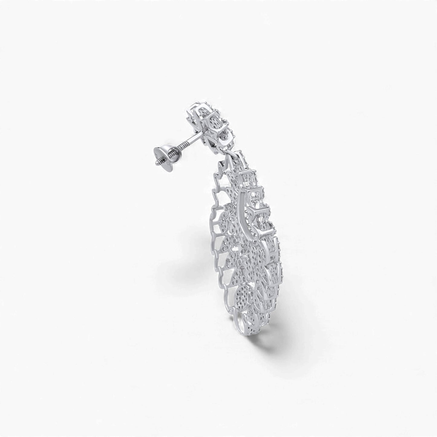 Silver earring with intricate design on a white background