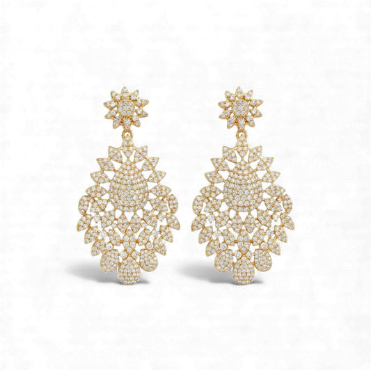 Pair of gold earrings with intricate designs on a white background