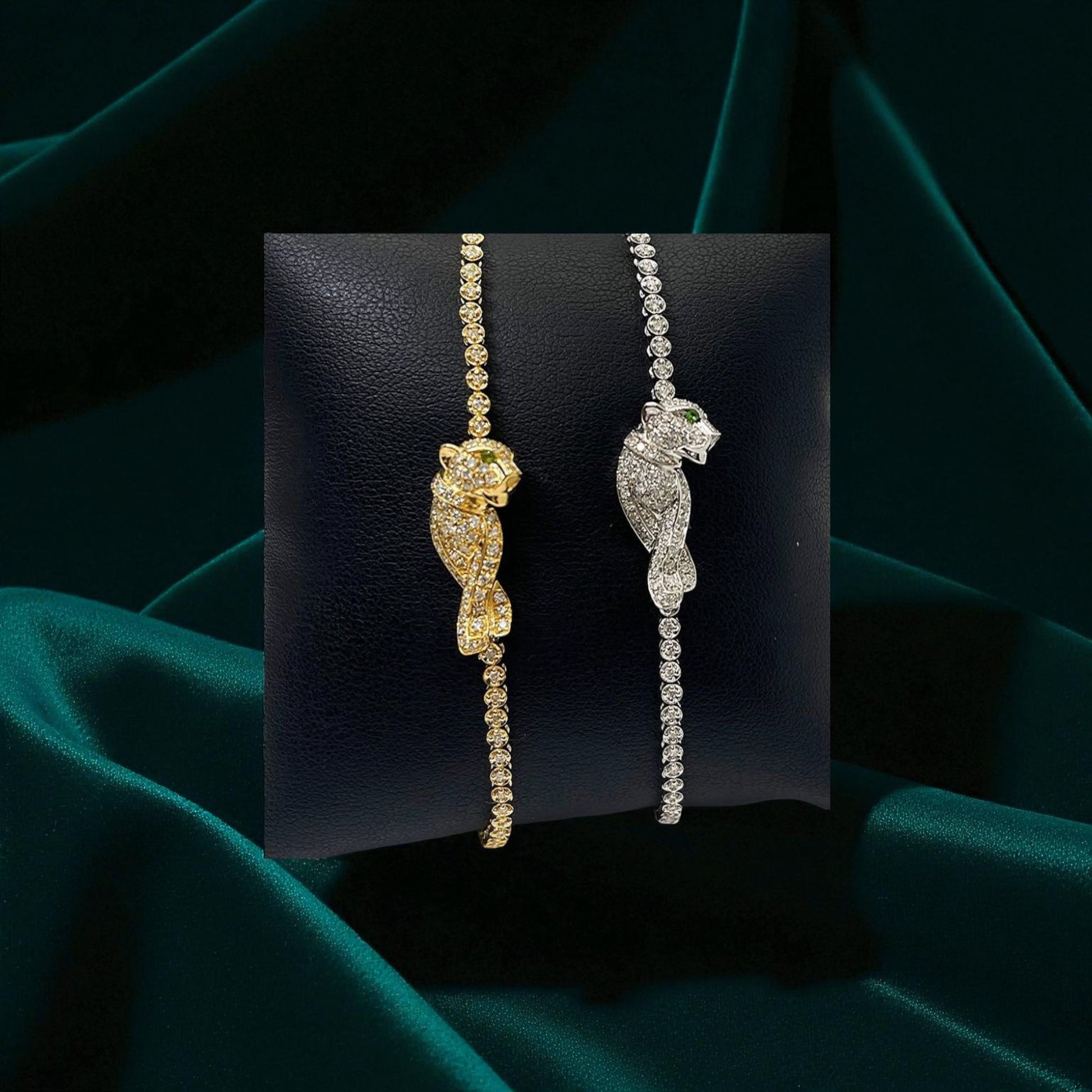 Gold and silver cat-shaped earrings on a dark green fabric background