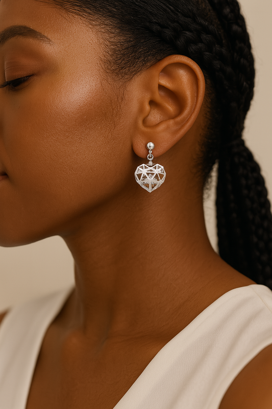 Close-up of a woman wearing a silver geometric heart earring against a neutral background