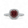 Ring with a red gemstone and diamond accents on a white background