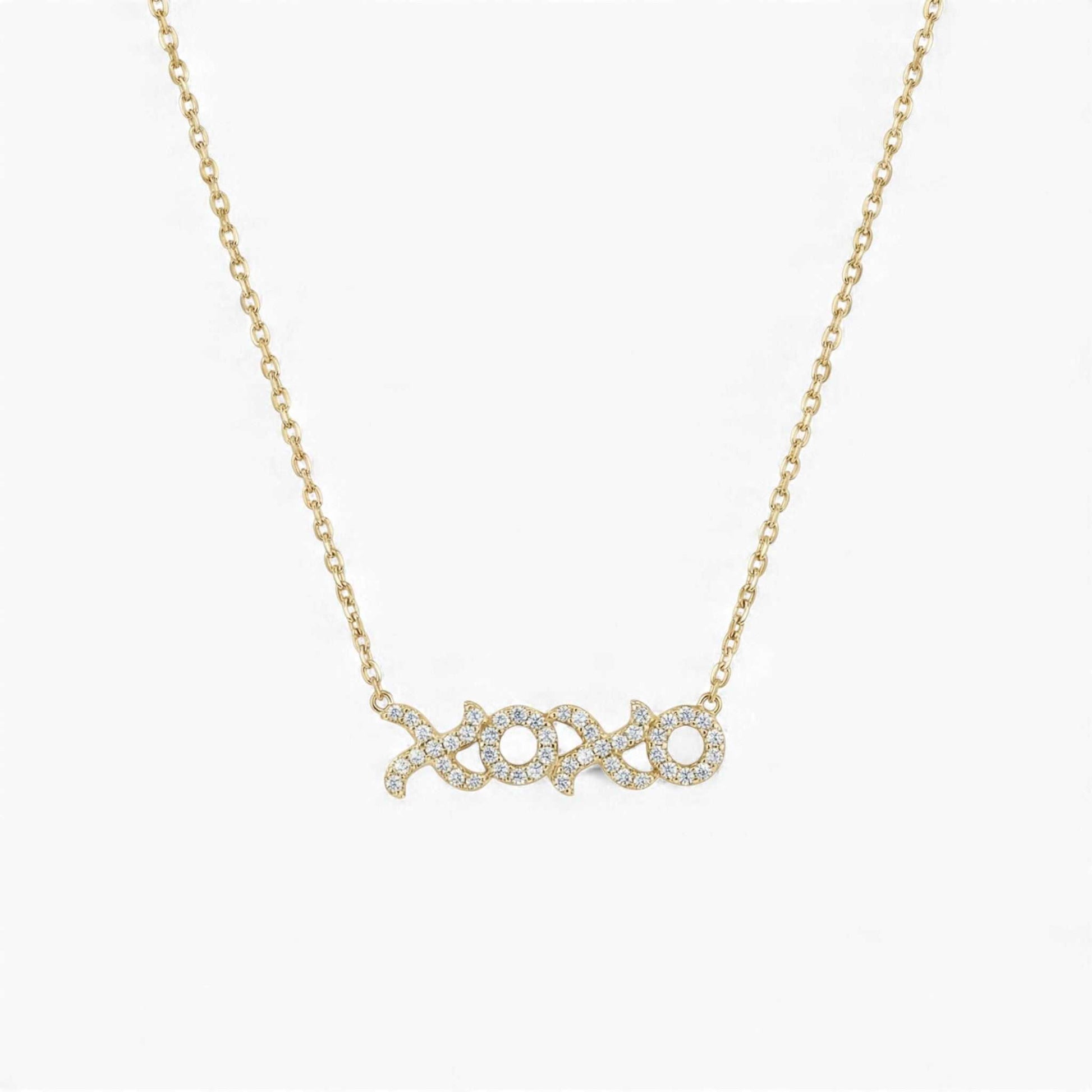 Gold necklace with 'xoxo' pendant on a white background