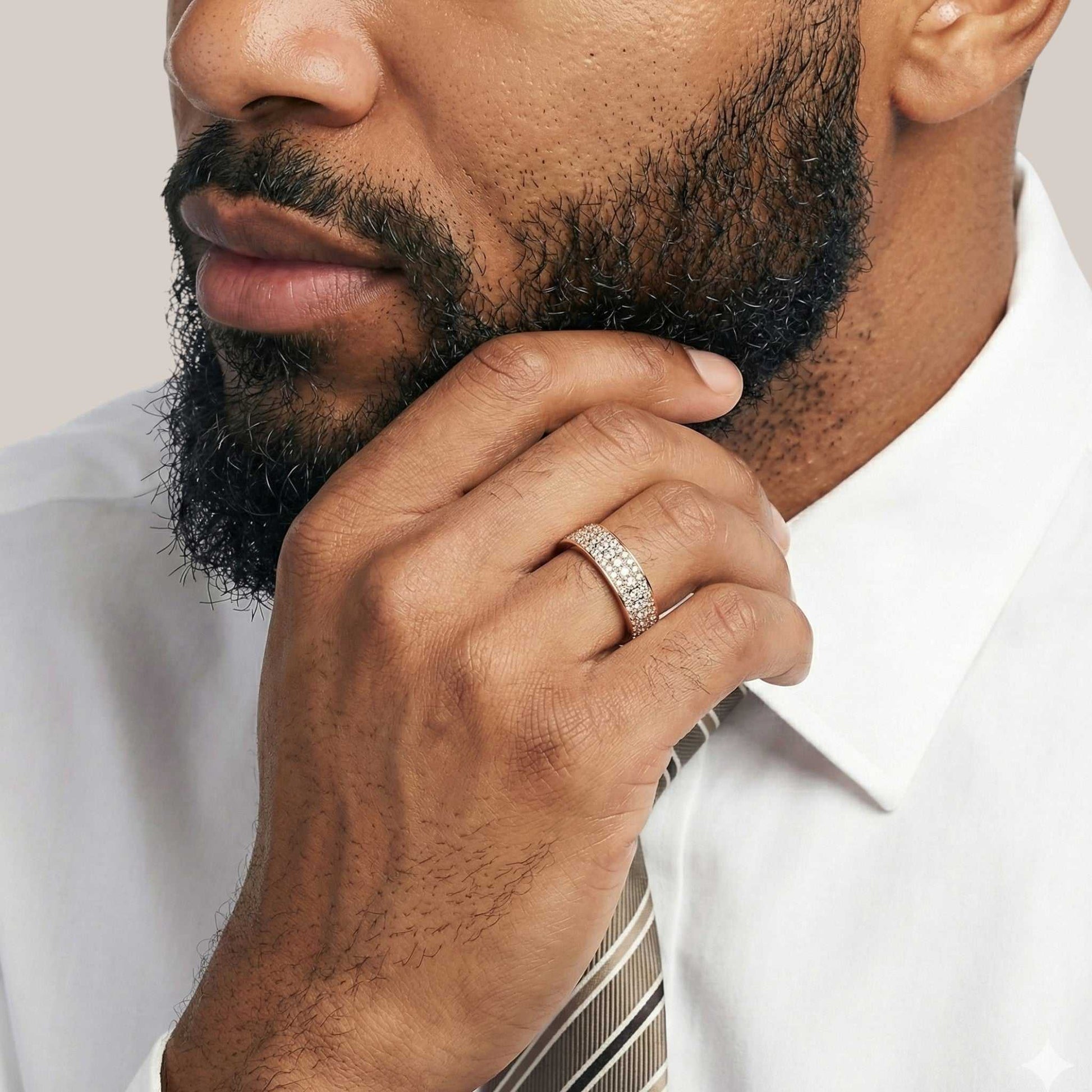 Man wearing a white shirt and tie with a close-up of his hand and ring.
