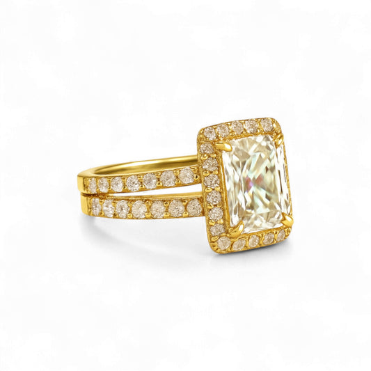 Gold ring with a large diamond and smaller diamonds on the band against a white background