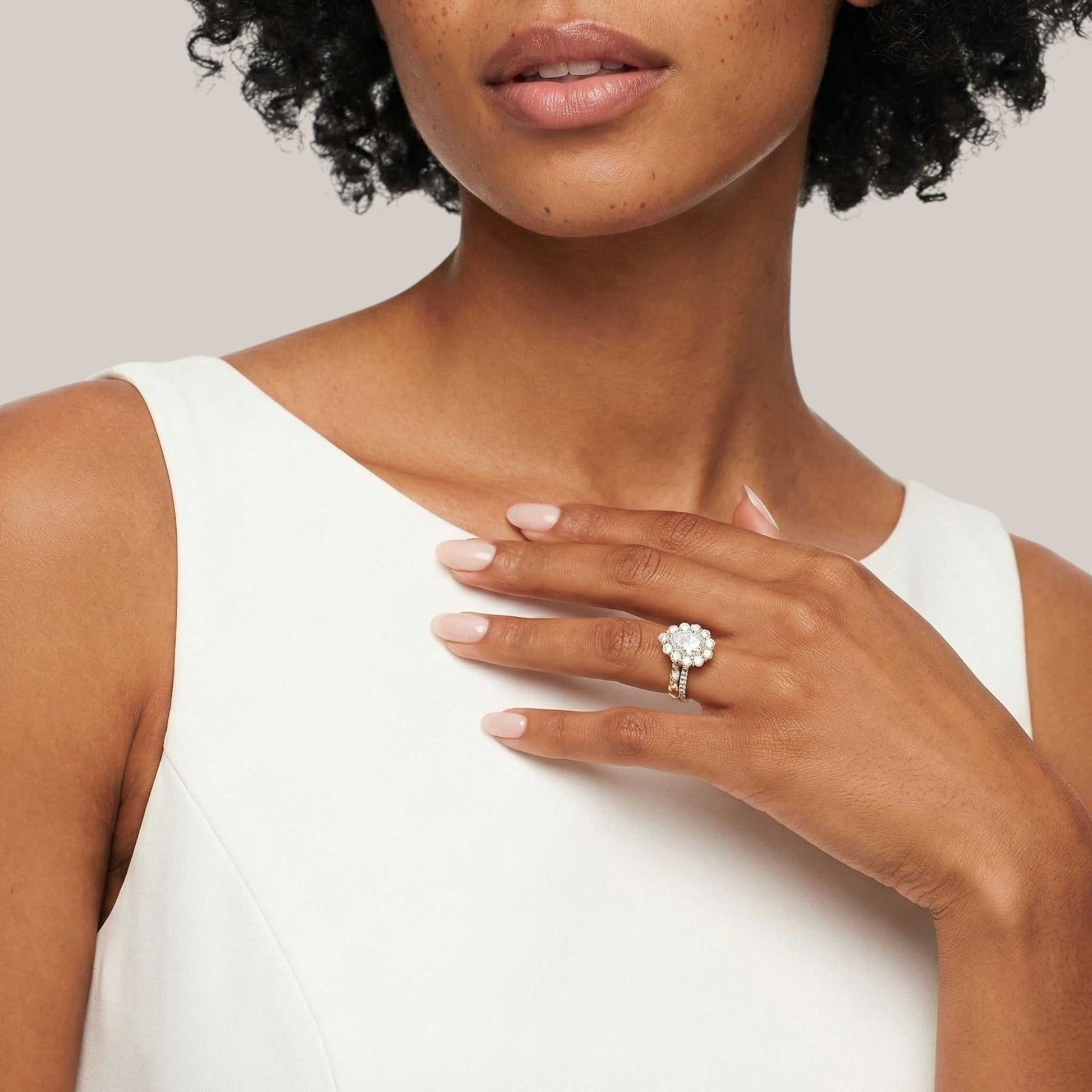 Woman wearing a diamond ring on her hand against a neutral background