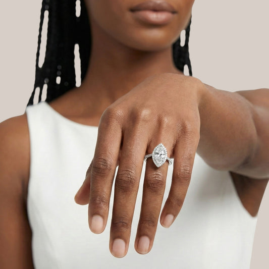 Woman wearing a diamond ring on her hand against a neutral background