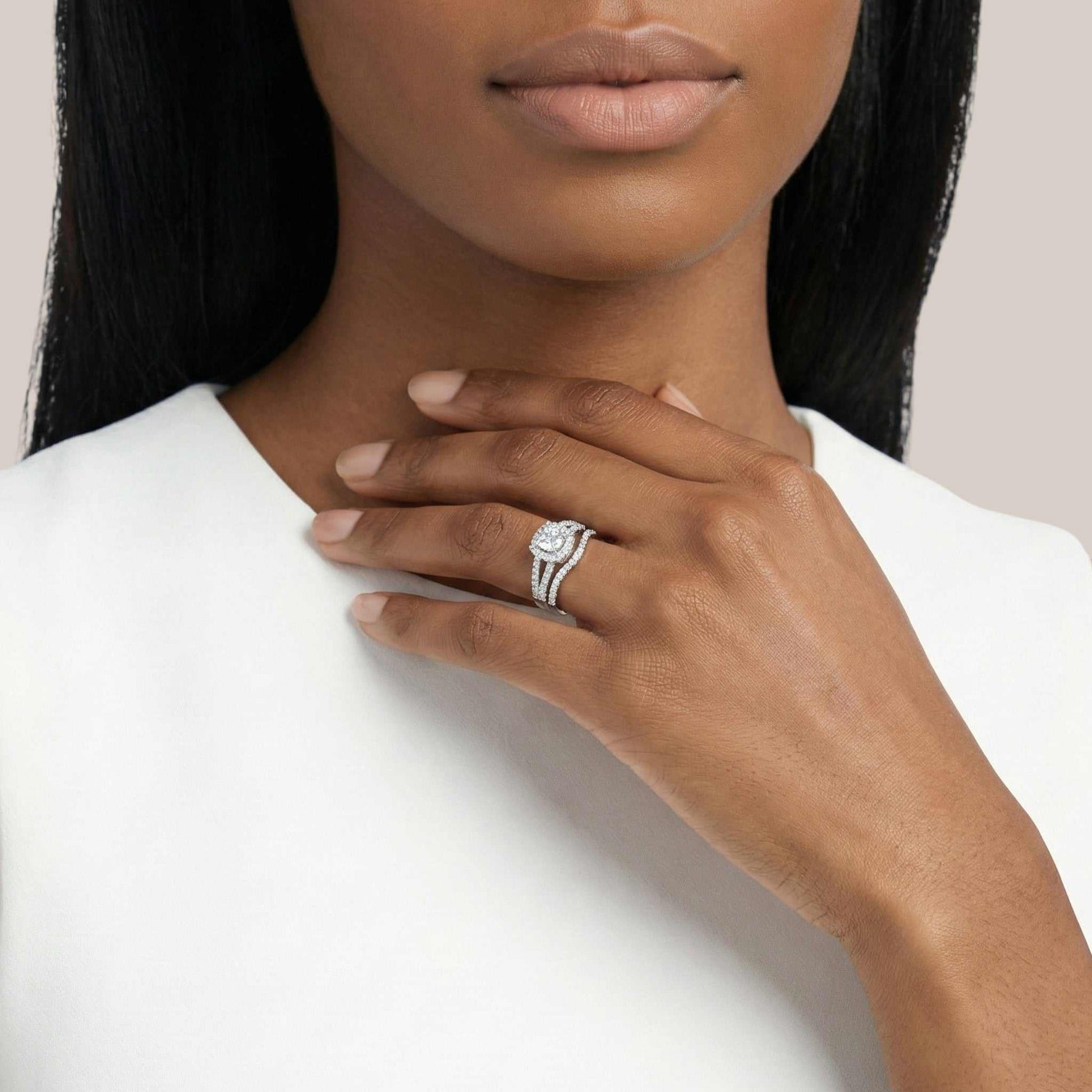 Woman wearing a diamond ring on her hand with a plain background