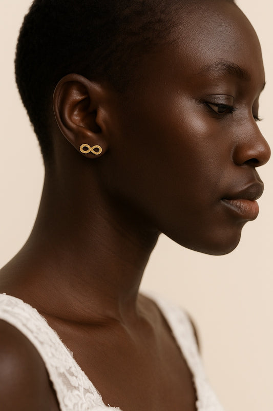 Woman wearing gold earrings with a beige background
